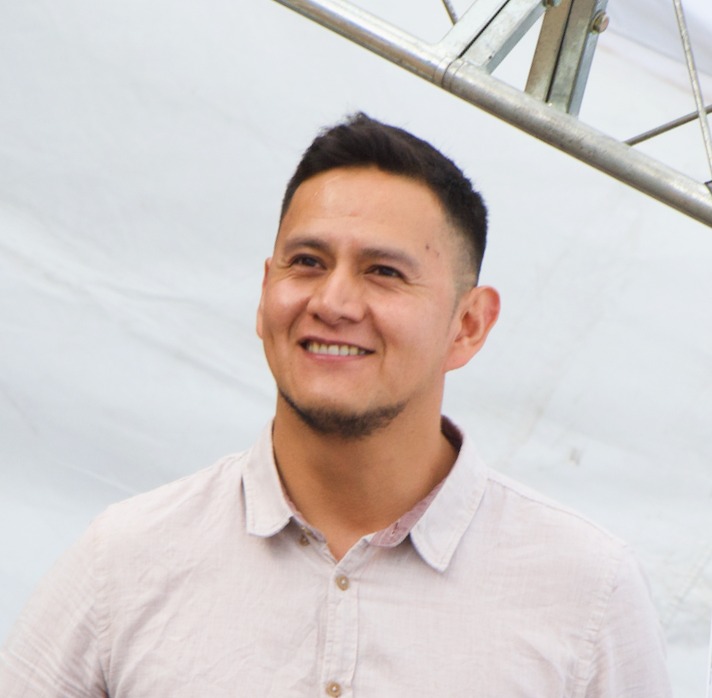 Smiling professional portrait of Sergio Arce, a software engineer, in a light shirt and neutral background